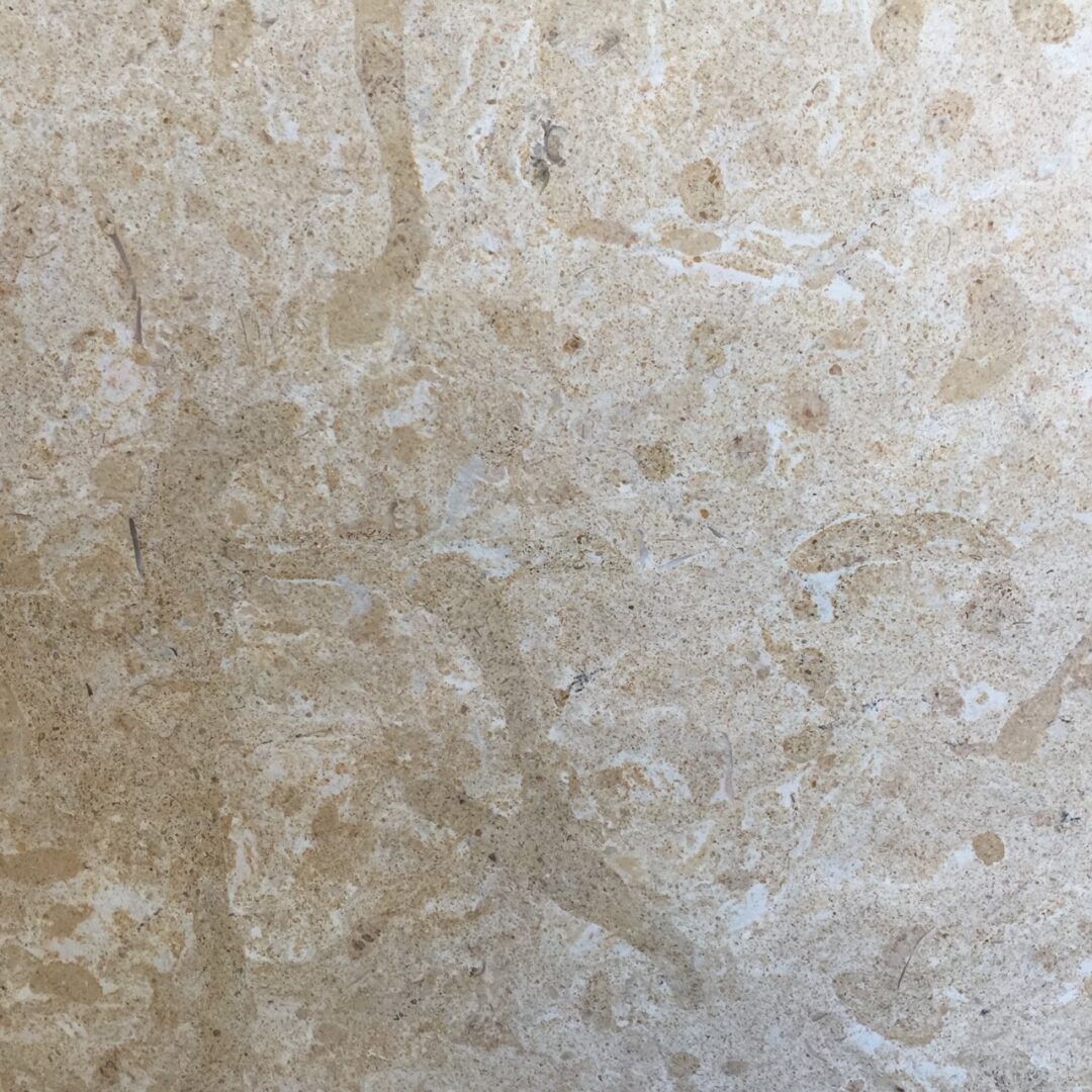 Close-up of beige marble surface with natural veining patterns.