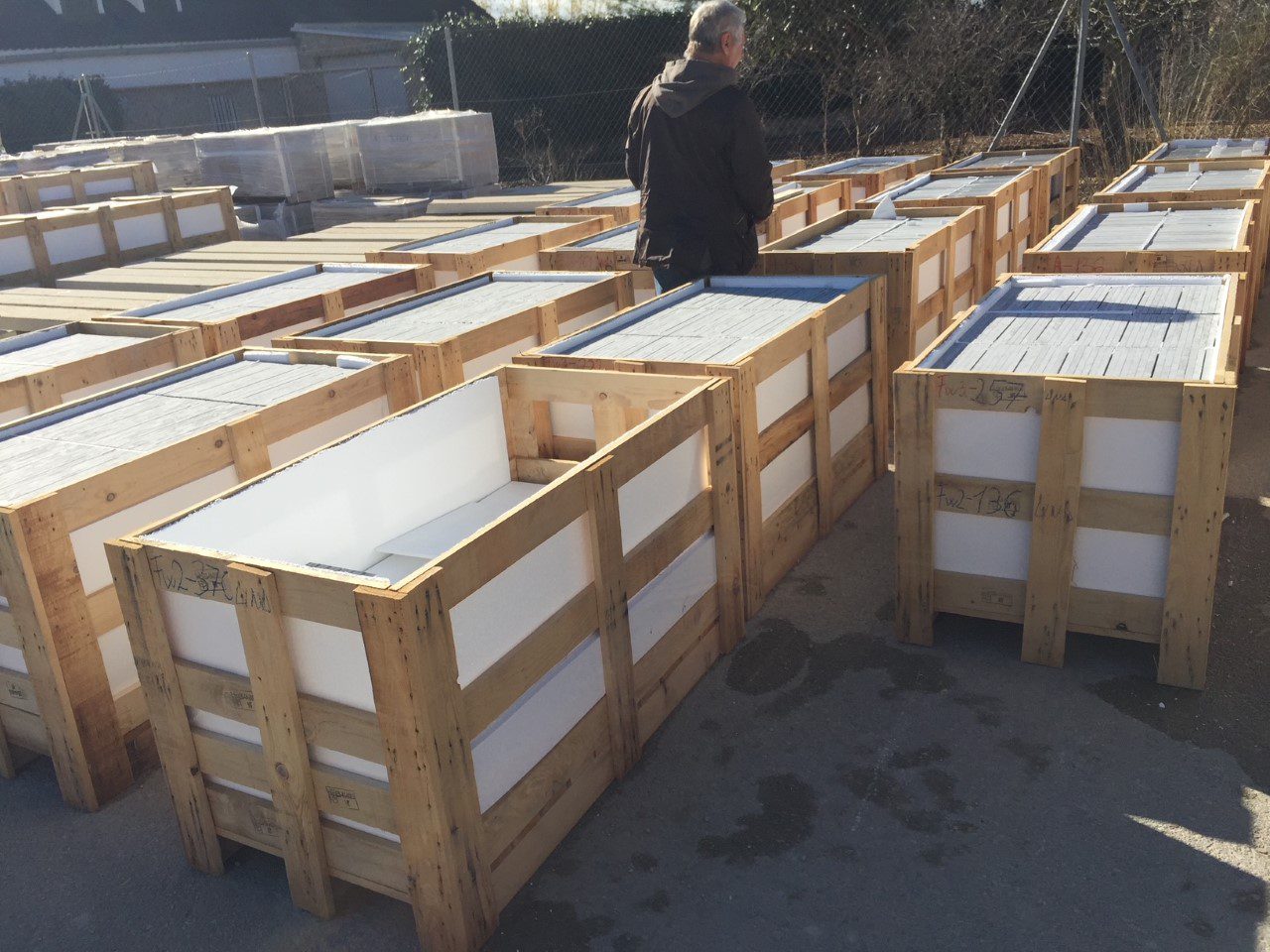 Wooden crates filled with white blocks arranged outdoors.