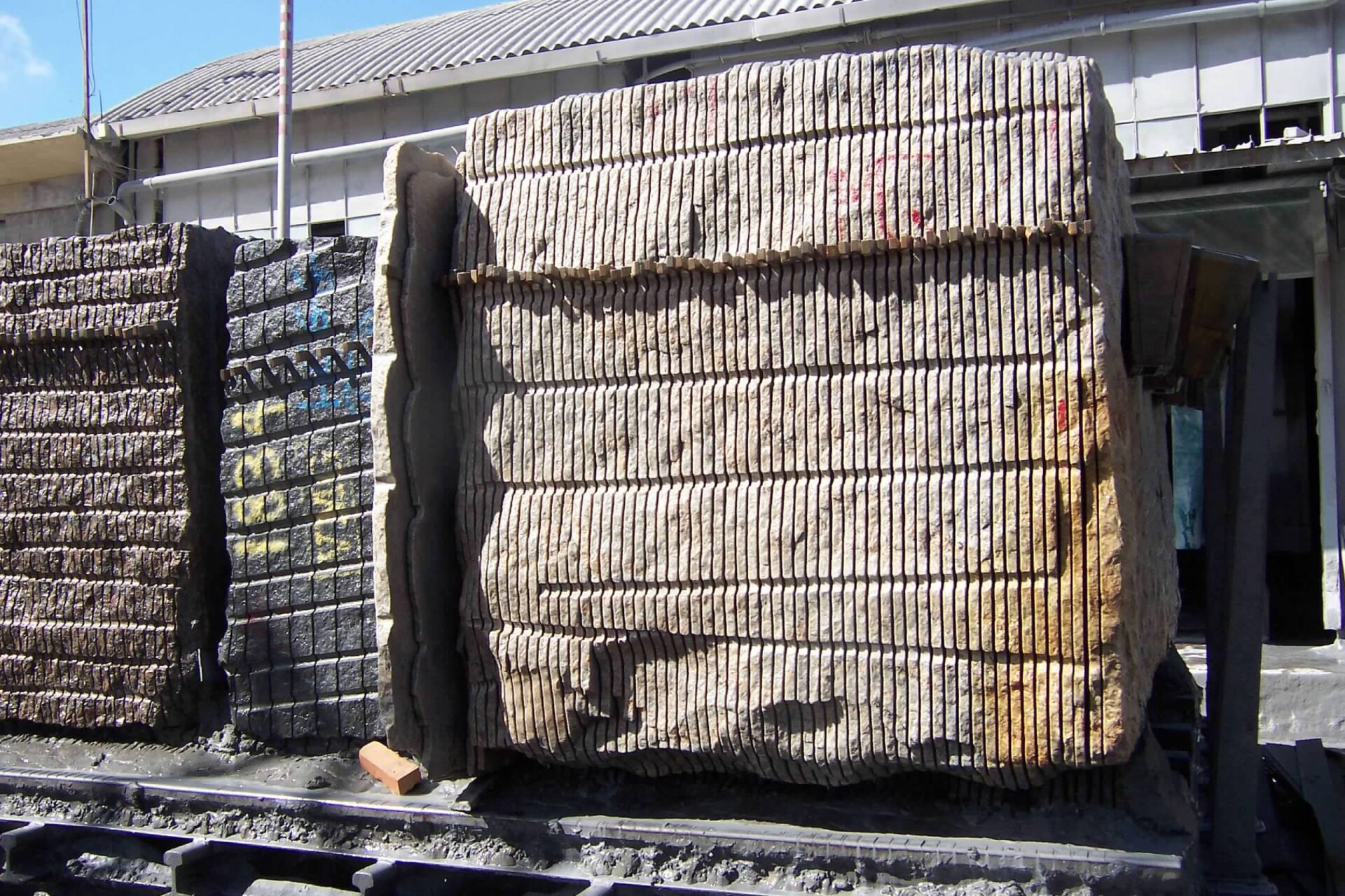 A large, weathered stone block with vertical grooves on its surface.