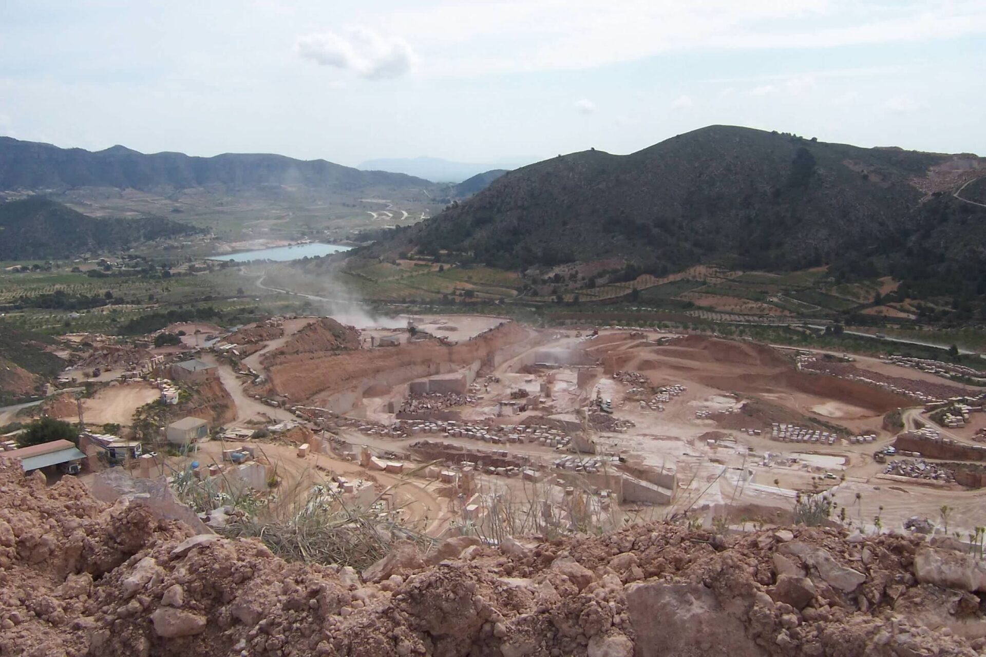 Expansive open-pit mining site in a mountainous region.