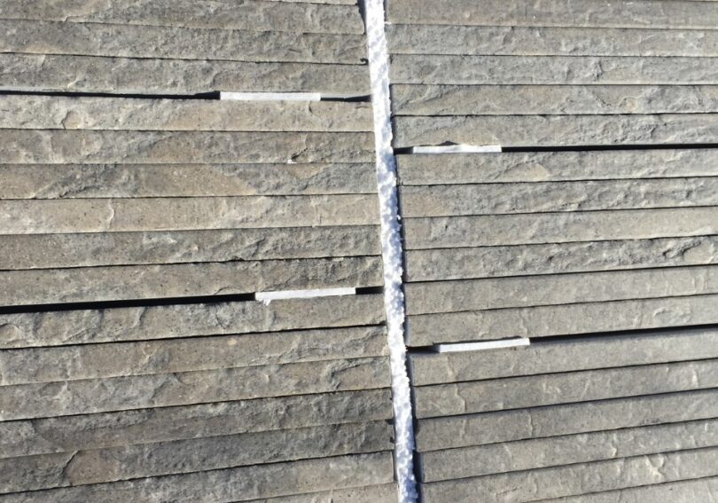 Stacked gray stone slabs with rough texture.